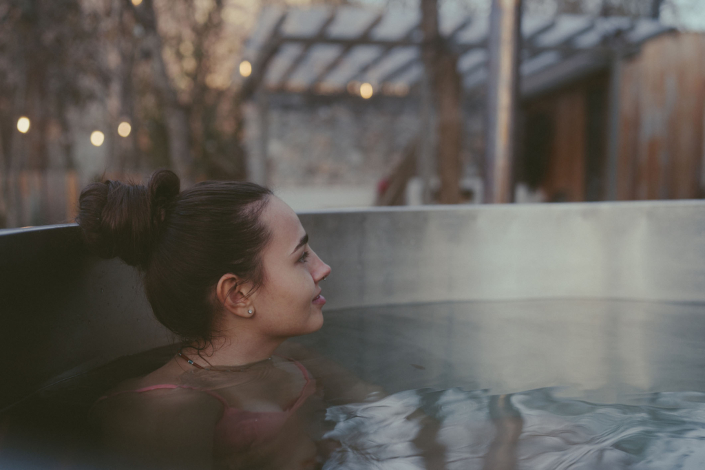 Vildmarksbad fra SPA Kompaniet med glasfiberindsats og integreret brændeovn, egnet til helårsbrug i haven